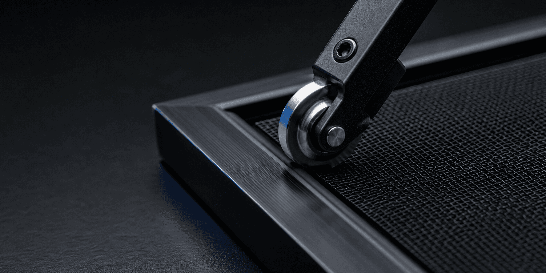 Macro view of a spline roller installing black spline into an aluminum window screen frame